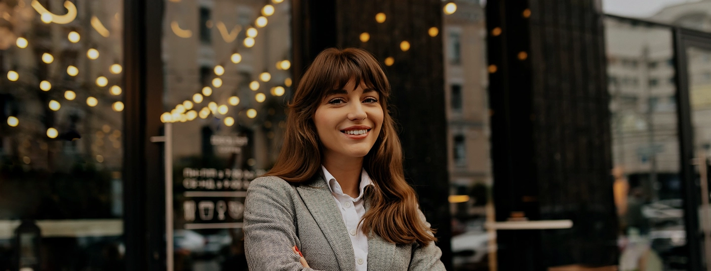 Woman in a gray blazer stands confidently