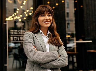 Smiling woman with long hair in a gray blazer 