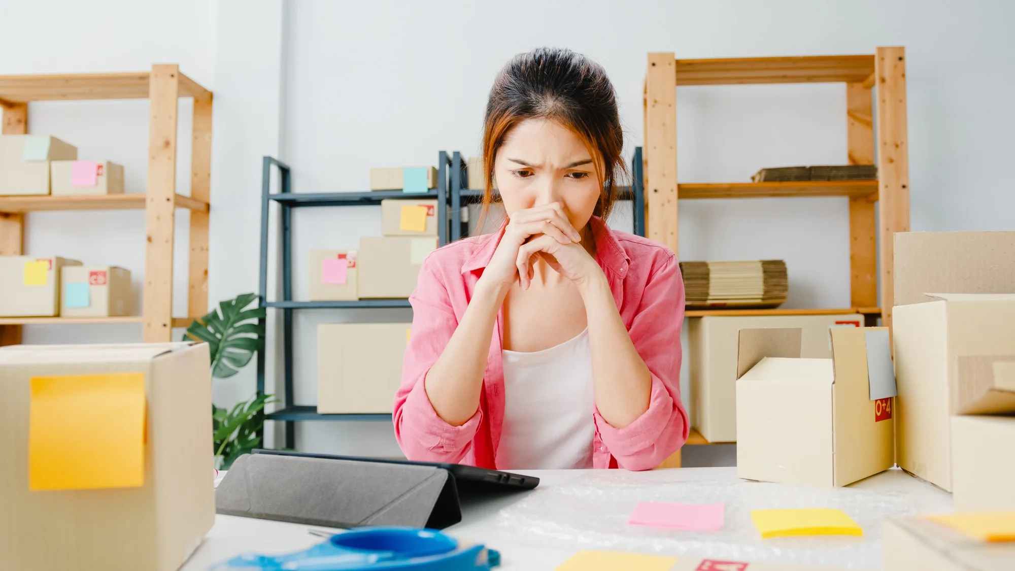 Woman in a pink shirt sits at a desk