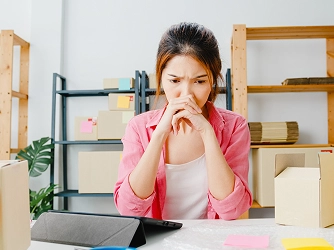 Woman in a pink shirt sits at a desk 