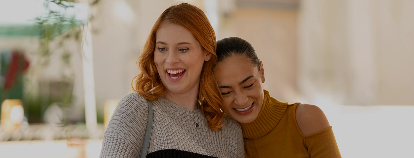 Woman in a red blazer and glasses works on a laptop