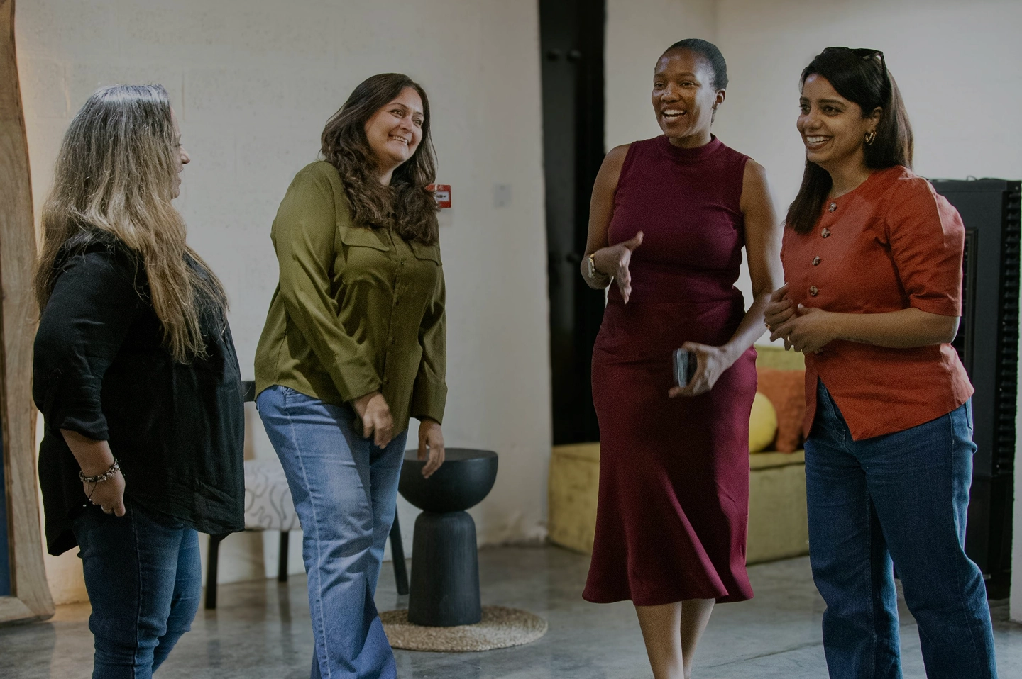 Four women standing together and conversing